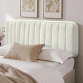 Ein rosa Samtkissen bildet eine weiche Rueckenlehne am Bett in Beige